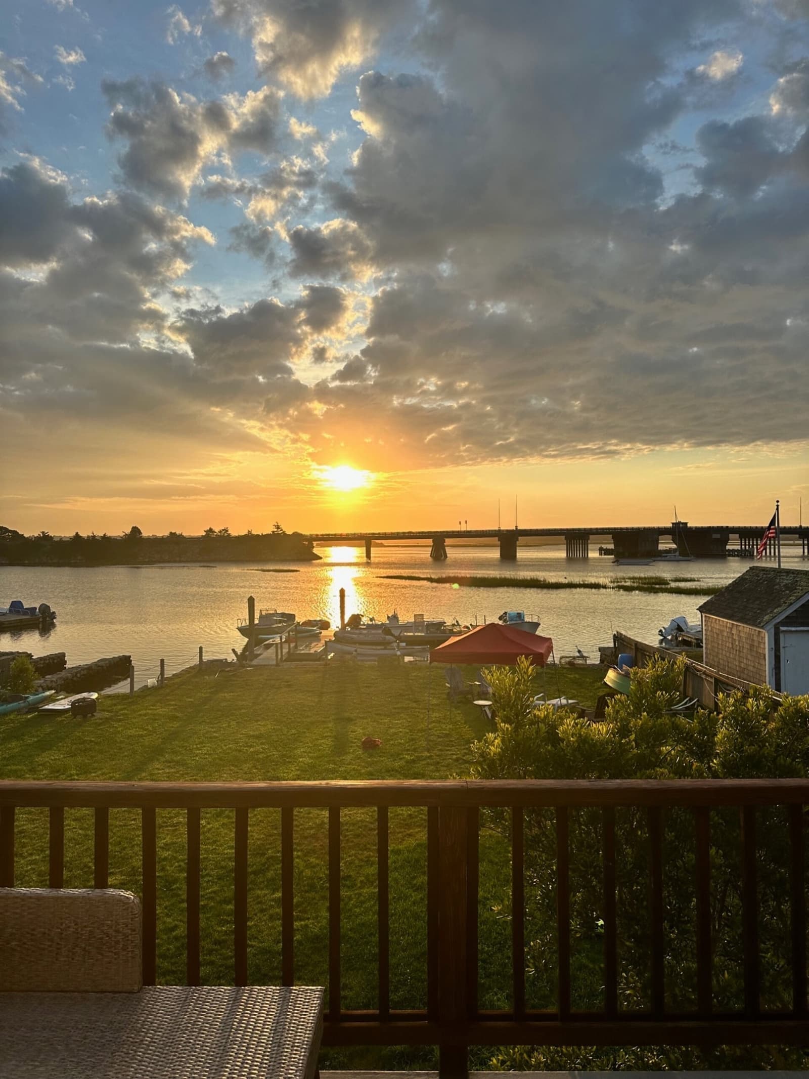 Sunset from the deck at 2042 Main Road overlooking backyard, harbor, and bridge