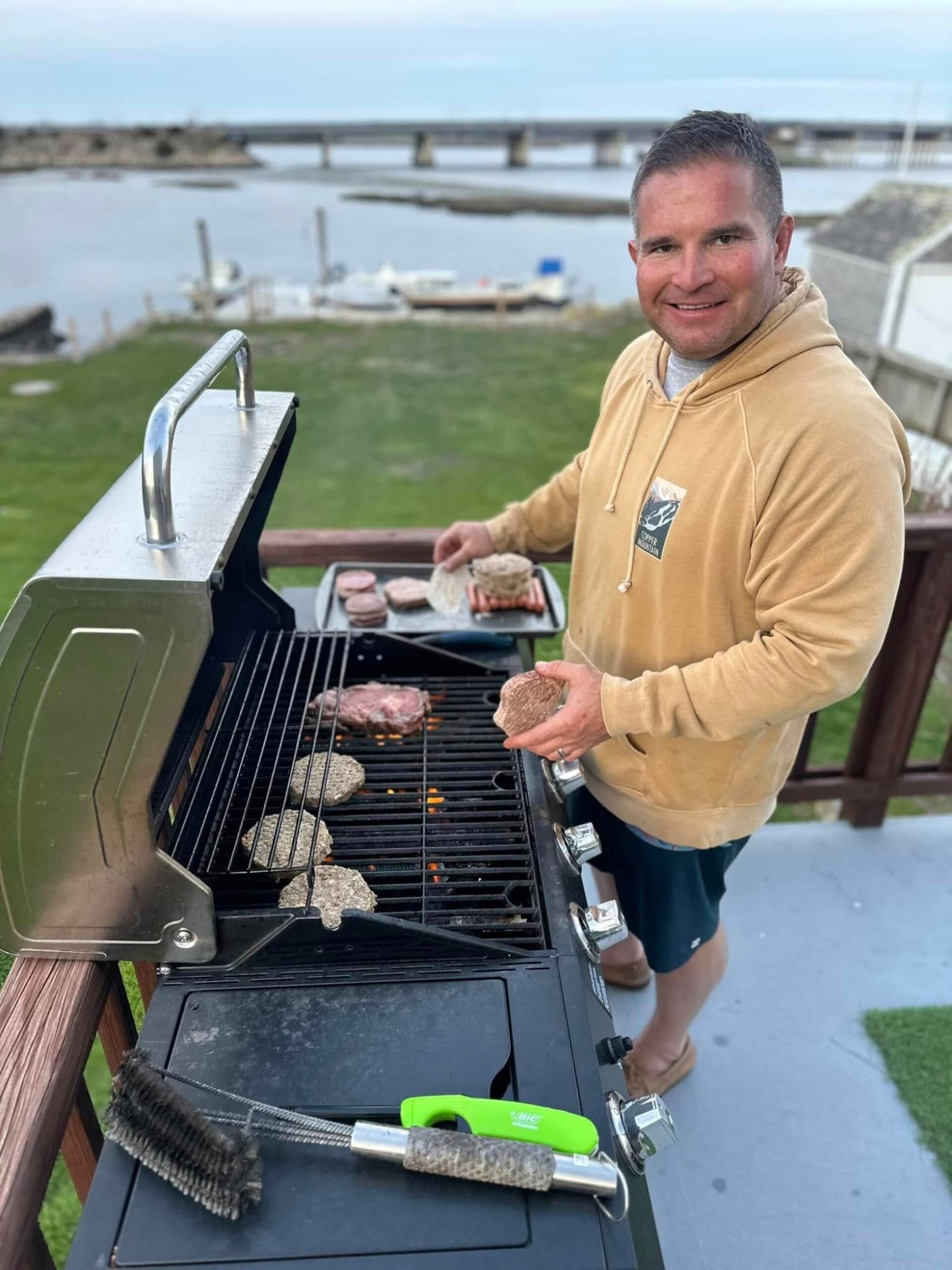 Grilling steaks with the bridge and harbor visible behind