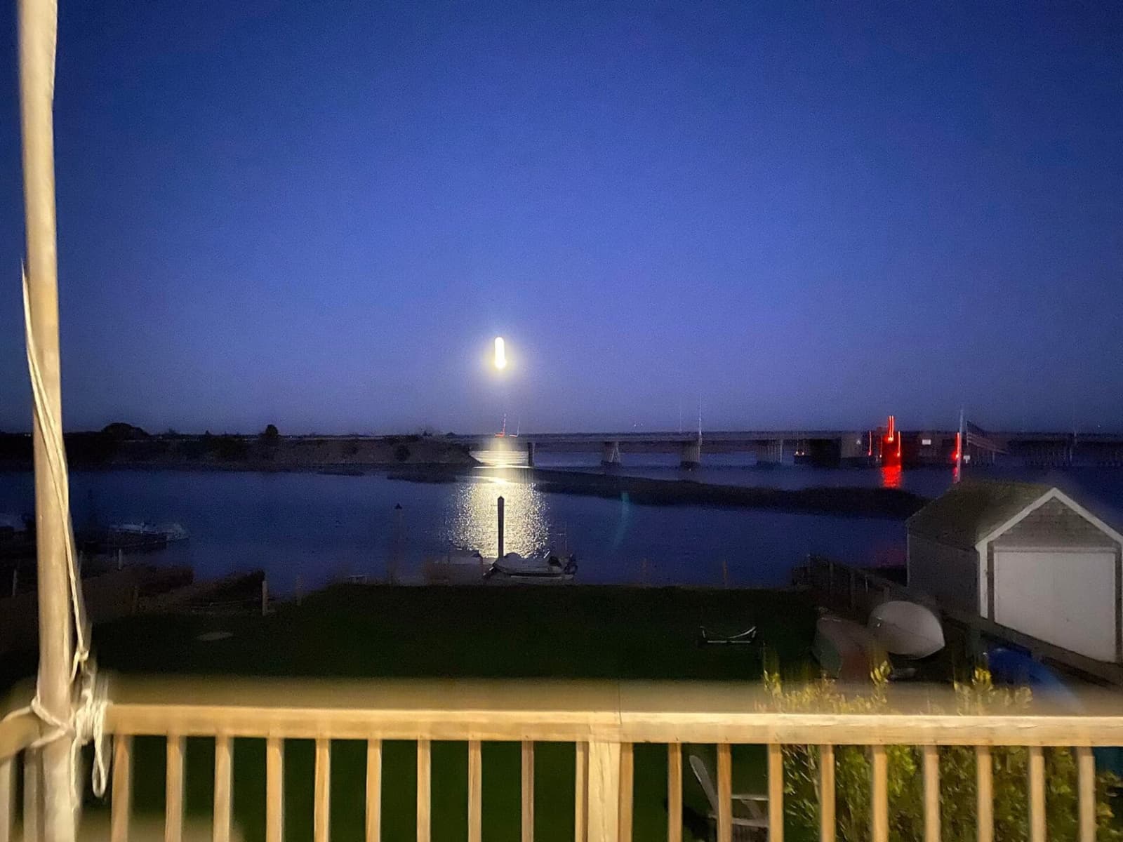 Moonrise over the bridge from the balcony railing, reflection on water