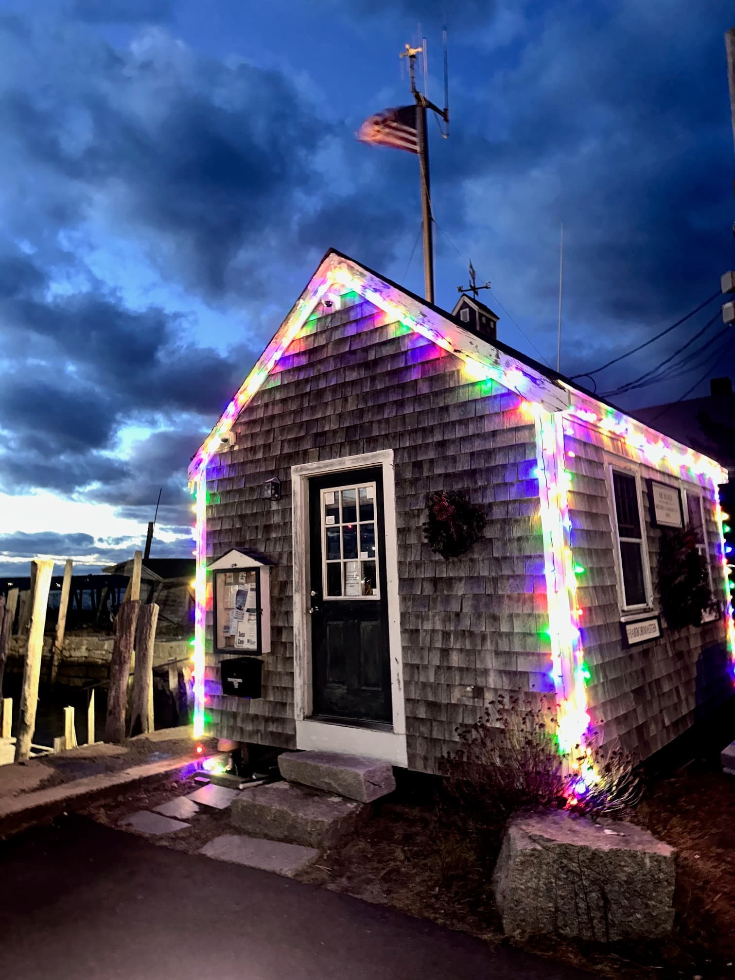Shingled harbor building with Christmas lights at Westport Point