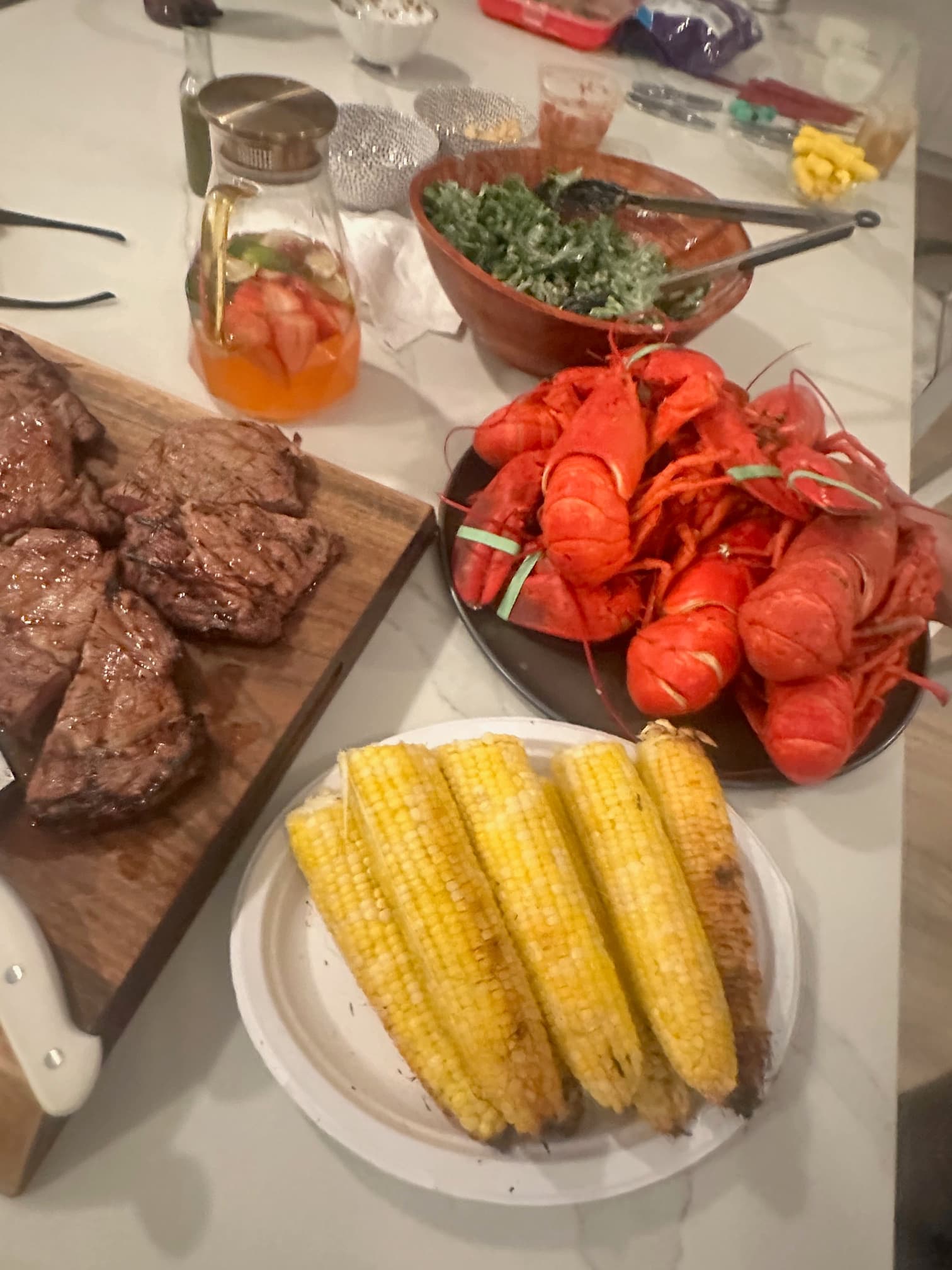 Lobsters, steaks, corn, and sangria on the table at 2042 Main Road